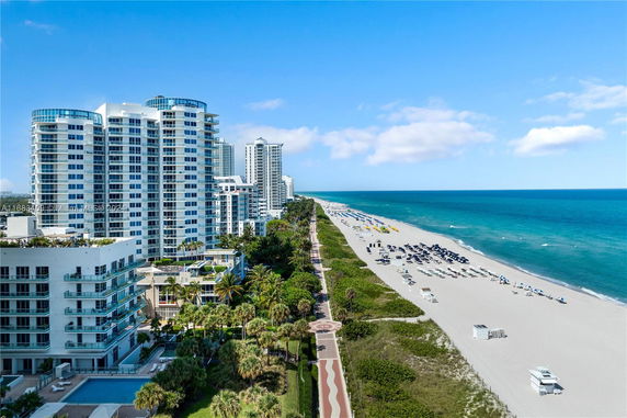 High-rise buildings along a coastline with a beach in view.