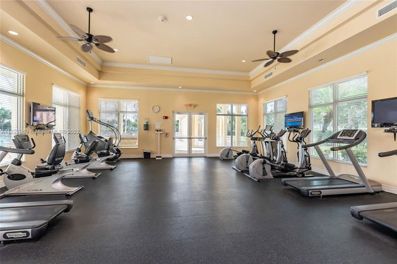 Interior of a gym with exercise equipment and large windows.