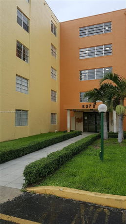 Entrance view of a multi-story apartment building with colored walls.