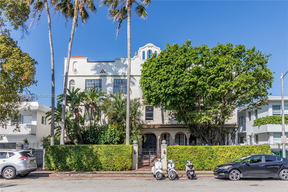 Front view of a multi-story building with arched windows and a tiled roof.