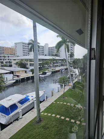 View from a building overlooking a canal with moored boats and nearby modern apartments.