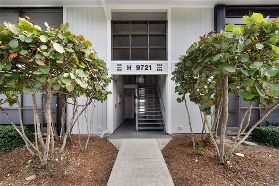 Front view of a building entrance with stairs and a sign displaying 'H 9721'.