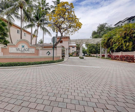 Front view of a large residential complex entrance with a sign reading 'Village East'.