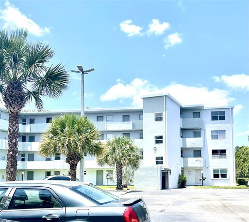 Front view of a multi-story apartment building with balconies.