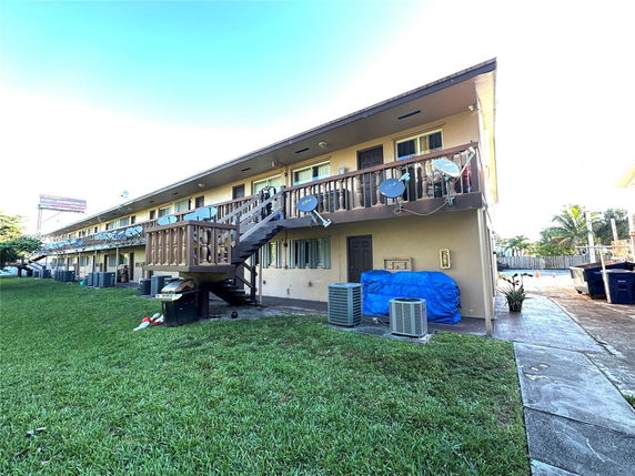 Front view of a two-story apartment building with balconies and staircases.
