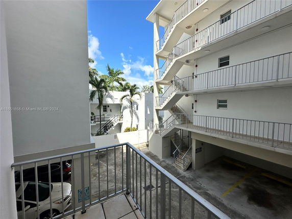 View of a multi-level building with white exterior and outdoor staircases.
