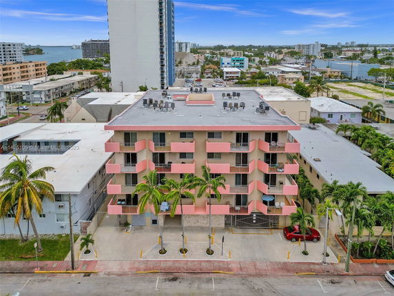 Front view of a multi-story residential building with pink balconies.