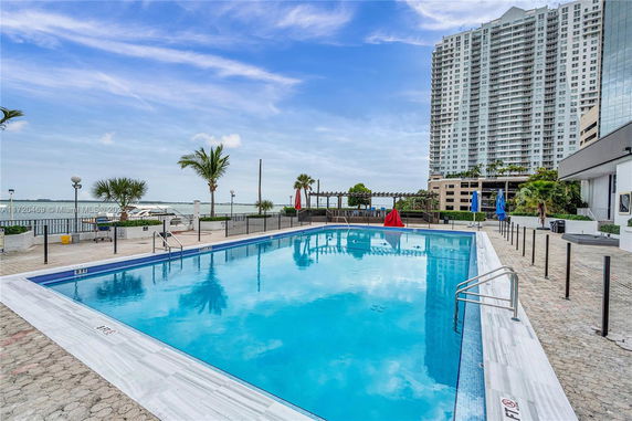 Outdoor swimming pool area with a view of a high-rise building and surrounding landscape.