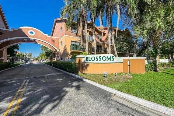 Front view of a multi-story residential building with an archway entrance.