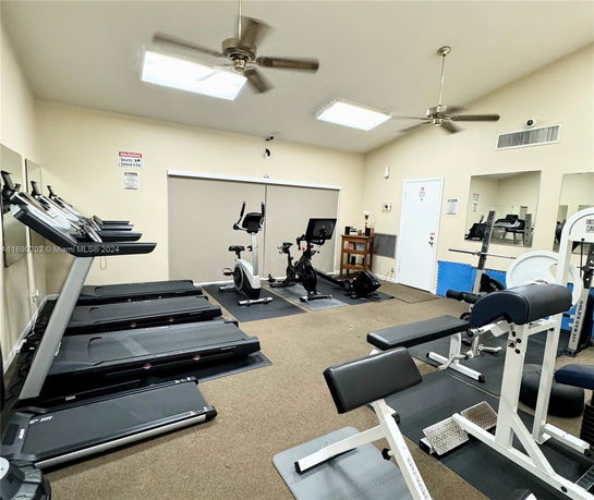 Indoor gym area with treadmills, exercise bikes, and workout equipment.