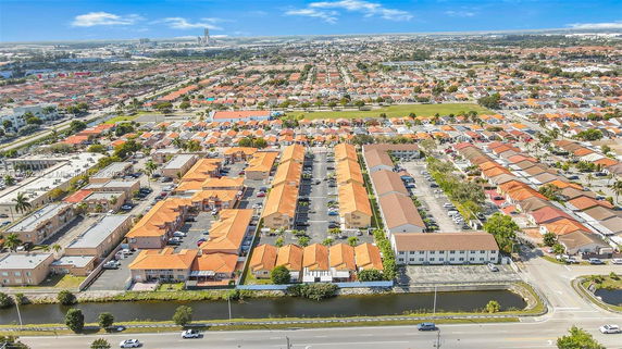 Aerial view of a suburban area with multiple residential buildings featuring orange and brown roofs.