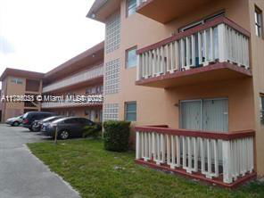 Front view of a multi-story apartment building with balconies.