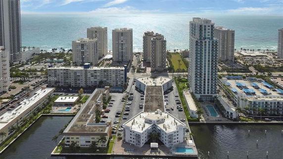 Panoramic view of coastal residential area with high-rise buildings and ocean in the background.