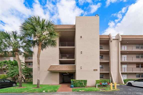 Front view of a multi-story apartment building with balconies.