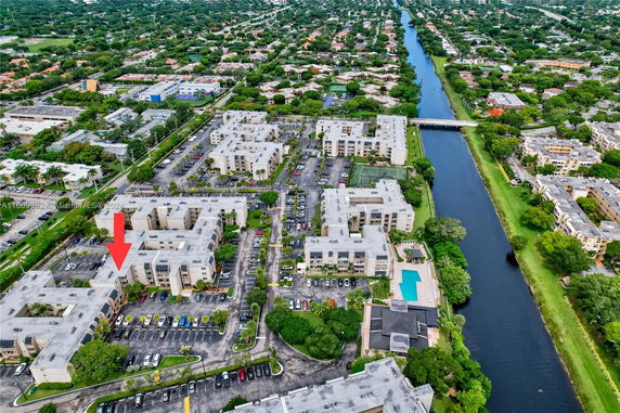 Aerial view of a large residential complex with multiple buildings and a canal running through the area.