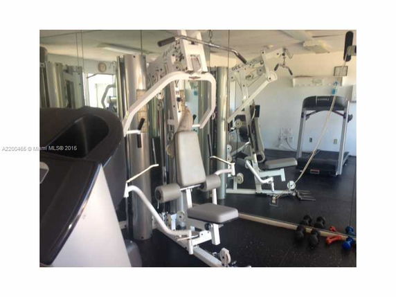 Indoor gym area with exercise machines and weights.
