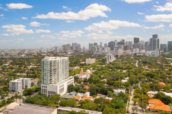 Panoramic view of a city with high-rise buildings and green areas.
