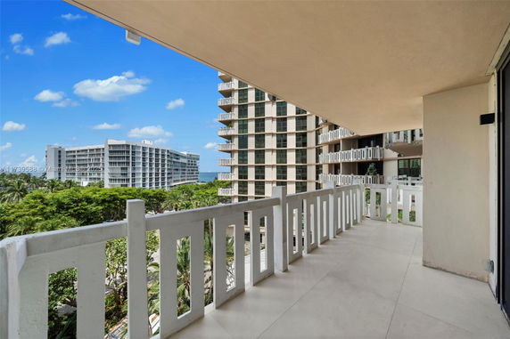 Balcony view showing modern high-rise buildings and greenery.