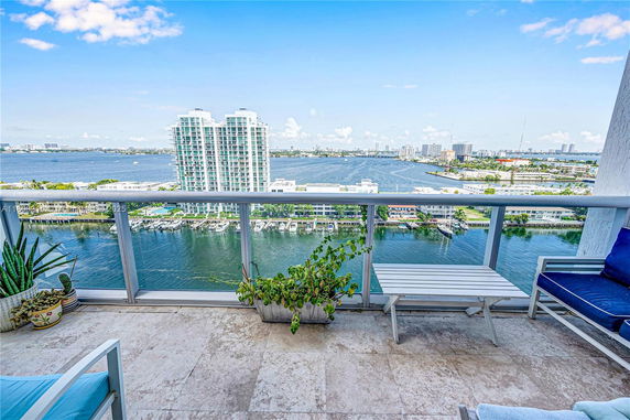Panoramic view from a balcony showing a water body and distant buildings.