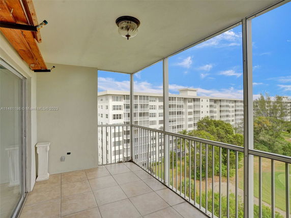 View from a balcony showing nearby residential buildings and greenery.