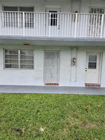 Front view of a two-story apartment building with balconies.