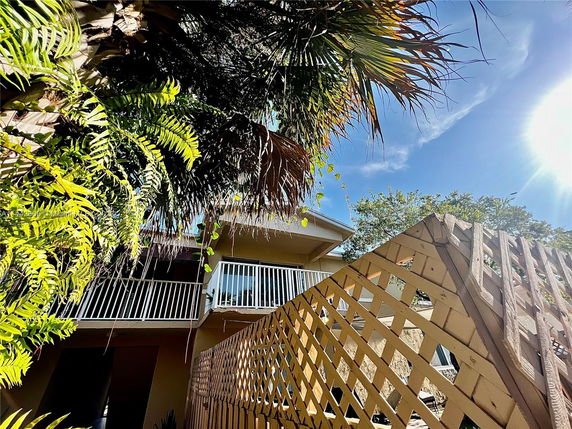 Front view of a house with a balcony and wooden fence.