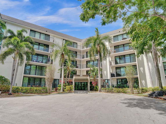Front view of a multi-story residential building with balconies and large windows.