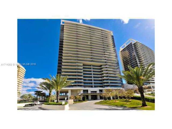Front view of a tall modern residential building with multiple balconies.