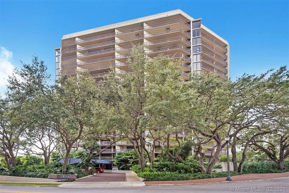 Front view of a multi-story apartment building with large balconies.