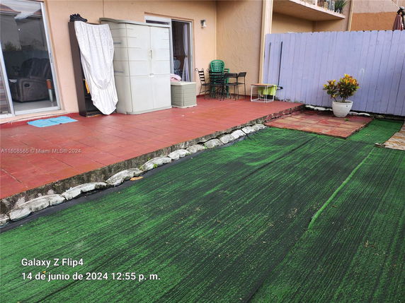 Outdoor patio area with artificial grass and seating.