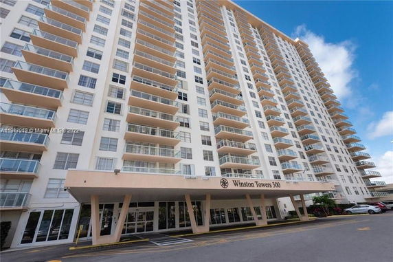 Front view of a high-rise residential building with multiple balconies.