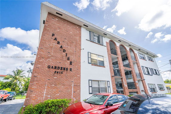 Front view of a multi-story brick building named Paradise Gardens II.