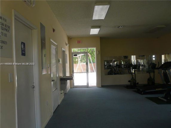 Indoor fitness area with gym equipment and mirrors.
