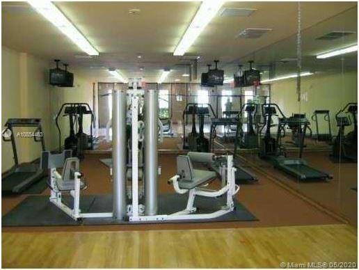 Indoor gym area with exercise equipment including treadmills and weight machines.