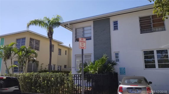 Front view of a two-story building with flat roofs and large windows.