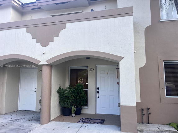 Front view of a two-story building entrance with archways and decorative trim.
