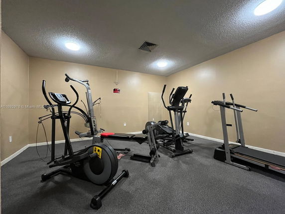 Indoor gym area with various exercise equipment including treadmills and stationary bikes.