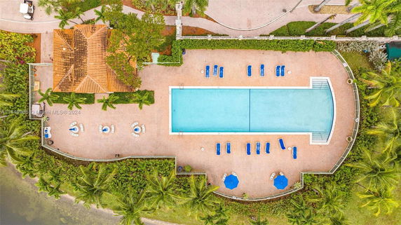 Aerial view of a swimming pool area with surrounding greenery.