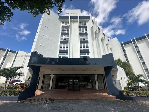 Front view of a multi-story building with a modern design and large windows.