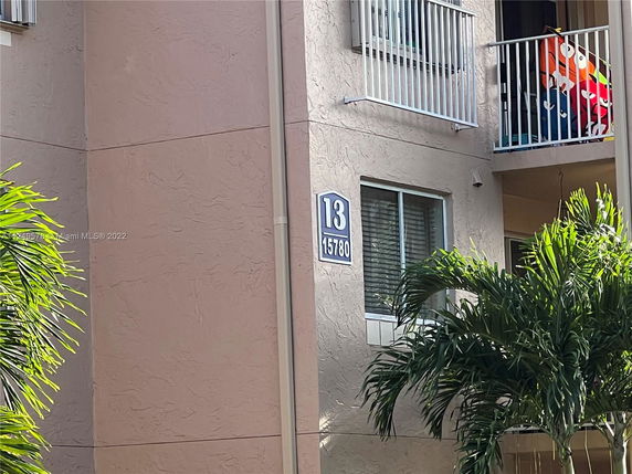 Exterior view of a building with a balcony and numbered sign.