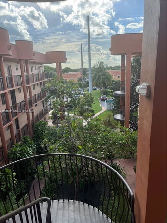 View from a residential building showing surrounding greenery and multiple floors with balconies.