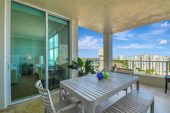View of surrounding areas seen from a covered balcony with an outdoor dining table.