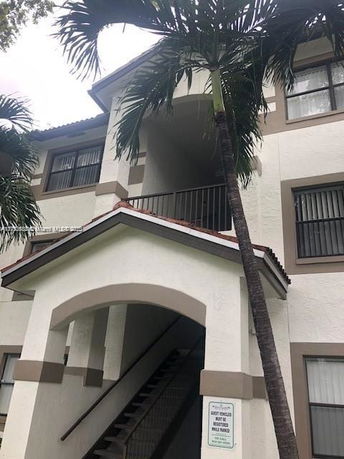 Front view of a multi-story residential building with an arched entrance.
