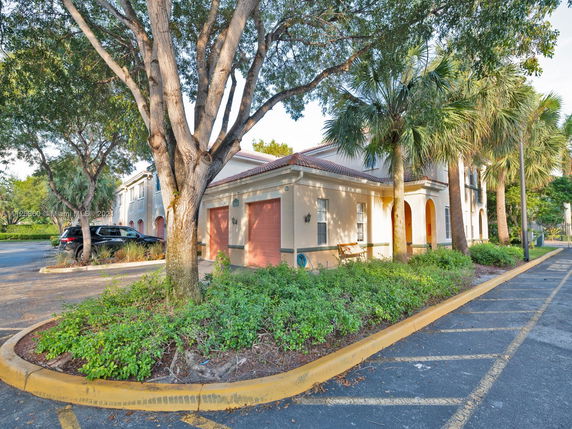 Front view of a two-story building with a garage and arched entryway.