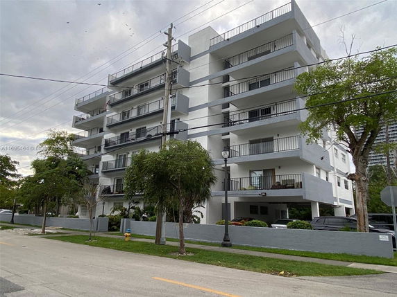 Front view of a multi-story apartment building with balconies.