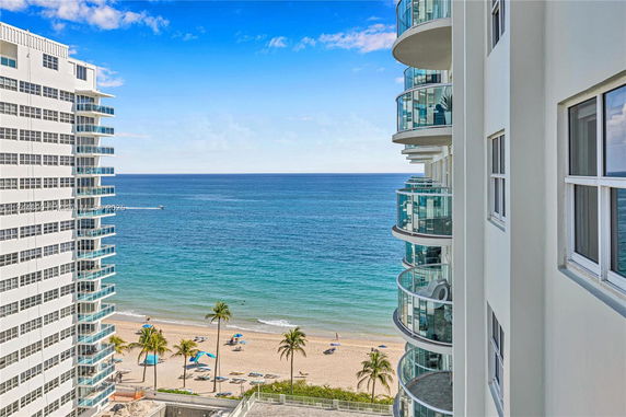 View of ocean and beach with high-rise buildings featuring balconies.