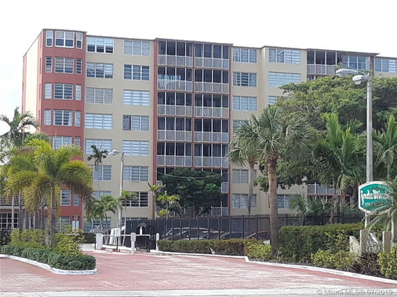 Front view of a multi-story apartment building with multiple balconies.