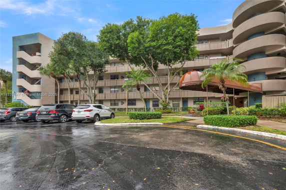 Front view of a multi-story residential building with outdoor parking.