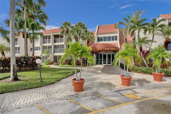 Front view of a multi-story residential building with an entrance canopy.