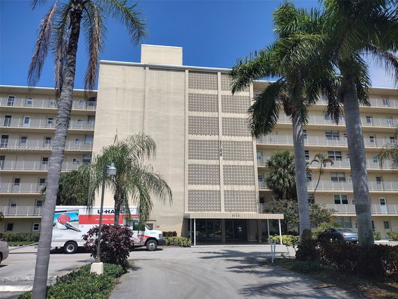 Front view of a multi-story building with balconies and a decorative facade.